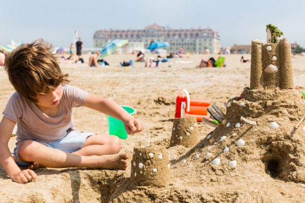 Enfant et chateau de sable sur la plage de Deauville